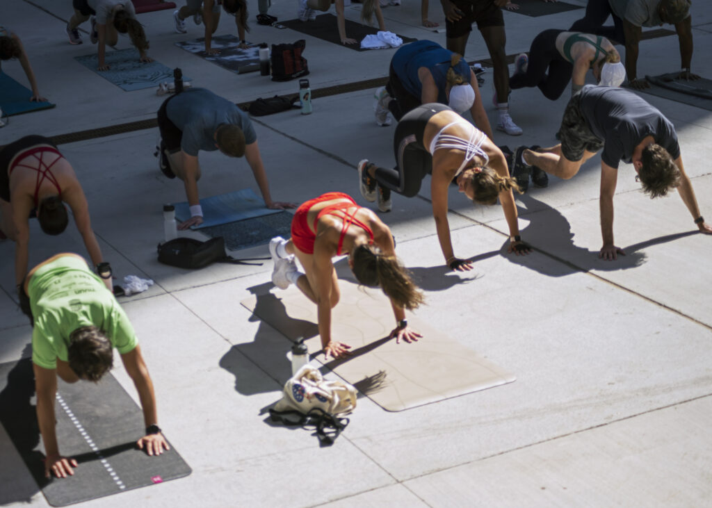 Group fitness participants completing a HIIT sequence at rooftop Sunday Reset event with Alchemy Collective.